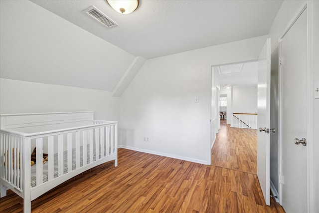 2055 Pine River Dr, Houston, TX 77339 - unfurnished bedroom with wood finished floors, lofted ceiling, and baseboards