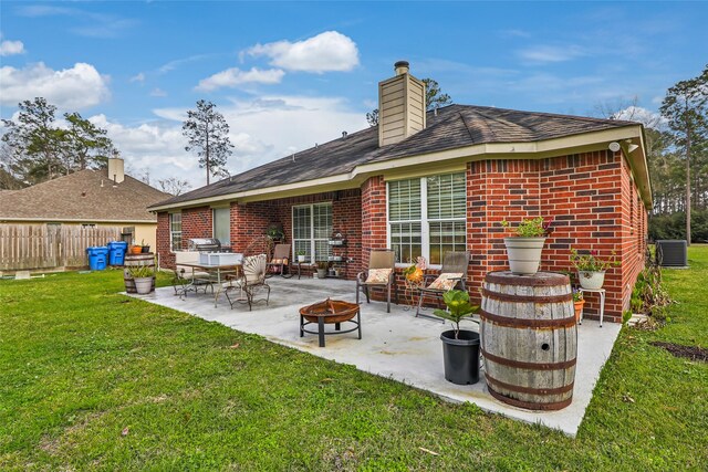 19715 Desna Dr, Porter, TX 77365 - rear view of house featuring a fire pit, a patio, central AC unit, brick siding, and a chimney