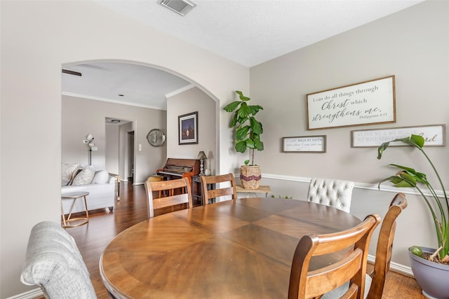 19715 Desna Dr, Porter, TX 77365 - dining space featuring arched walkways, wood finished floors, crown molding, and baseboards