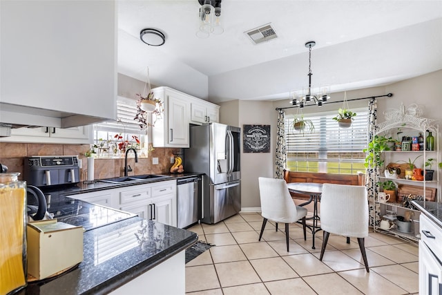 19715 Desna Dr, Porter, TX 77365 - kitchen featuring a sink, appliances with stainless steel finishes, a chandelier, healthy amount of natural light, and vaulted ceiling