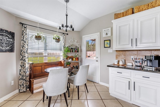 19715 Desna Dr, Porter, TX 77365 - dining room with a chandelier, vaulted ceiling, light tile patterned floors, and baseboards