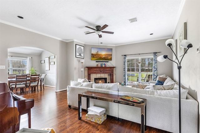 19715 Desna Dr, Porter, TX 77365 - living area with arched walkways, a ceiling fan, wood finished floors, a fireplace, and ornamental molding