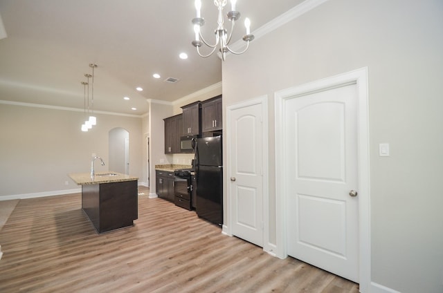 6523 Tuskegee St, Houston, TX 77091 - kitchen with black appliances, crown molding, dark brown cabinetry, arched walkways, and baseboards