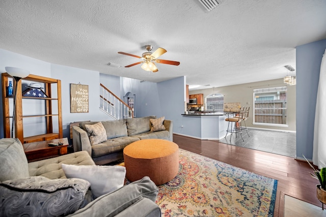 1802 Moston Dr, Spring, TX 77386 - living area with a ceiling fan, wood finished floors, stairs, a textured ceiling, and baseboards