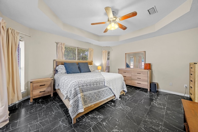 1802 Moston Dr, Spring, TX 77386 - bedroom featuring baseboards, a tray ceiling, marble look tiles, and a ceiling fan