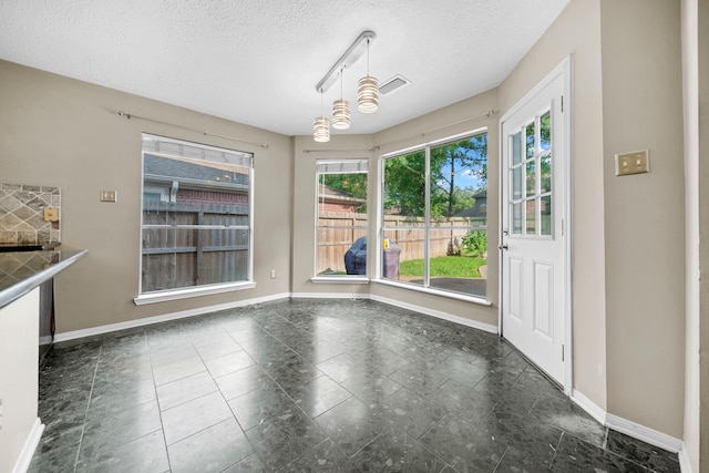 1802 Moston Dr, Spring, TX 77386 - unfurnished dining area with baseboards and a textured ceiling