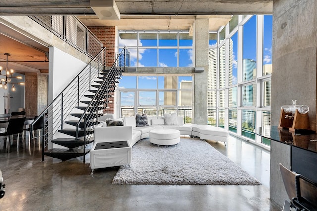 2000 Bagby St Unit 13430, Houston, TX 77002 - living area with a towering ceiling, expansive windows, stairs, finished concrete flooring, and a chandelier