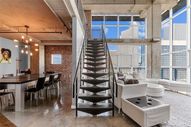 2000 Bagby St Unit 13430, Houston, TX 77002 - stairway with concrete floors, a chandelier, brick wall, and a towering ceiling