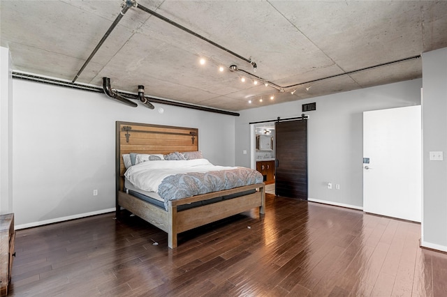 2000 Bagby St Unit 13430, Houston, TX 77002 - bedroom featuring a barn door, wood finished floors, and baseboards