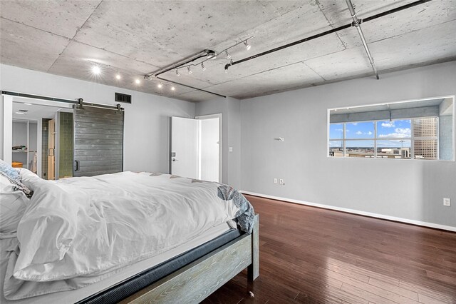2000 Bagby St Unit 13430, Houston, TX 77002 - bedroom with a barn door, baseboards, and wood finished floors