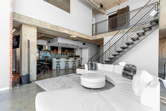 2000 Bagby St Unit 13430, Houston, TX 77002 - living room featuring a towering ceiling, stairway, finished concrete floors, and baseboards
