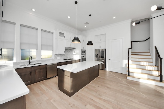 4005 Woodshire Village Ests, Houston, TX 77025 - kitchen with a sink, stainless steel appliances, light countertops, light wood-style floors, and a center island