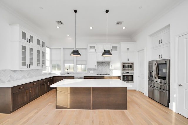 4005 Woodshire Village Ests, Houston, TX 77025 - kitchen with appliances with stainless steel finishes, a center island, light countertops, white cabinets, and dark brown cabinets
