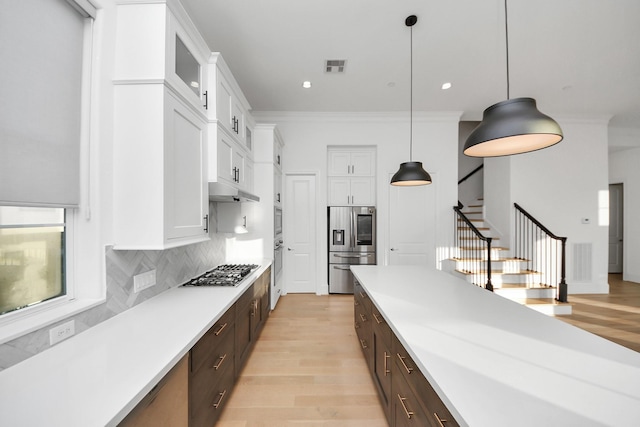 4005 Woodshire Village Ests, Houston, TX 77025 - kitchen with stainless steel appliances, white cabinetry, light wood-type flooring, light countertops, and dark brown cabinetry