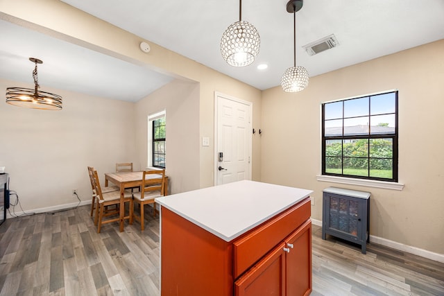 2915 Robertson St, Houston, TX 77009 - kitchen with light wood-type flooring, a chandelier, baseboards, a kitchen island, and pendant lighting