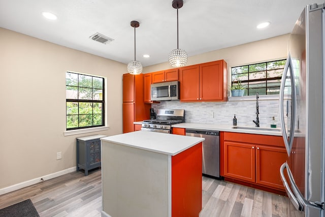2915 Robertson St, Houston, TX 77009 - kitchen with stainless steel appliances, light countertops, a sink, tasteful backsplash, and light wood-style flooring