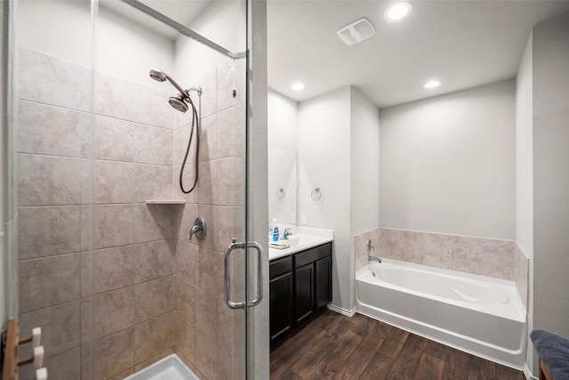 18693 Swainboro Dr, New Caney, TX 77357 - bathroom featuring wood finished floors, a stall shower, a garden tub, vanity, and recessed lighting