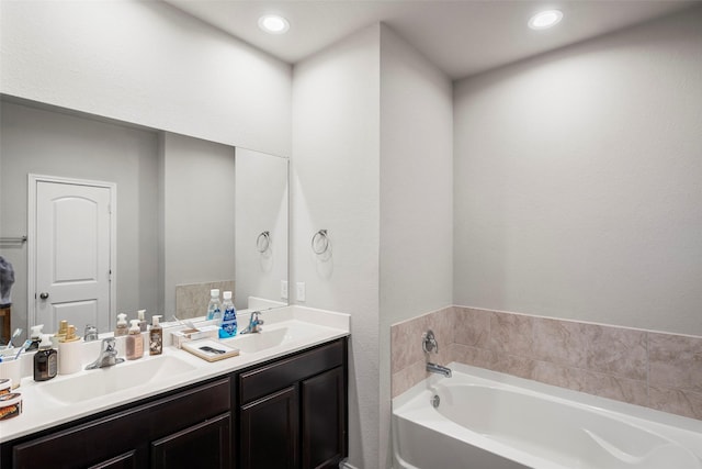 18693 Swainboro Dr, New Caney, TX 77357 - full bathroom featuring a bath, double vanity, and recessed lighting