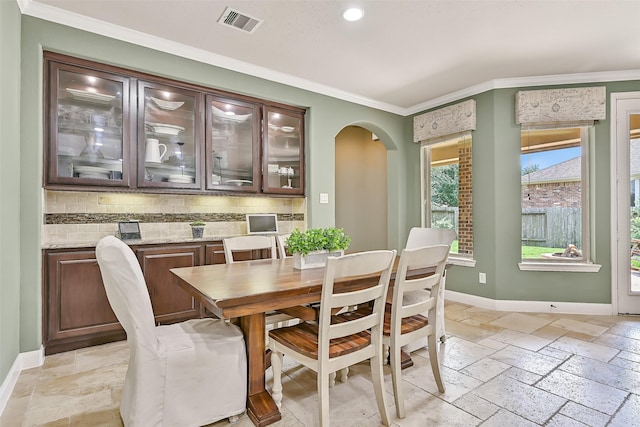1013 Bolivar Point Ln, Friendswood, TX 77546 - dining area with stone tile flooring, crown molding, arched walkways, baseboards, and recessed lighting