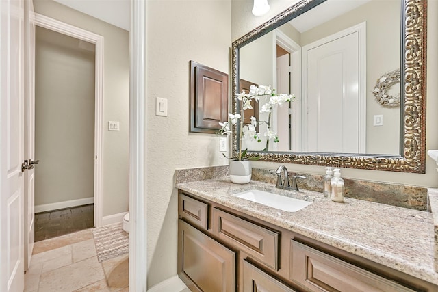 1013 Bolivar Point Ln, Friendswood, TX 77546 - bathroom with vanity, toilet, stone tile floors, and baseboards
