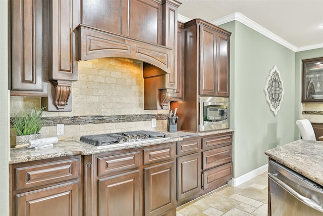 1013 Bolivar Point Ln, Friendswood, TX 77546 - kitchen with appliances with stainless steel finishes, baseboards, ornamental molding, decorative backsplash, and light stone counters