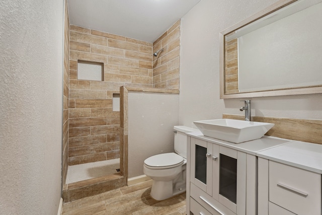6414 Crestridge St, Houston, TX 77033 - bathroom featuring toilet, a stall shower, vanity, a textured wall, and wood finished floors