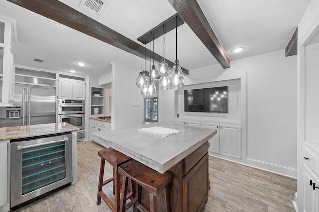 14119 Kiamesha Ct, Houston, TX 77069 - kitchen featuring beverage cooler, beam ceiling, light wood-style floors, appliances with stainless steel finishes, and white cabinetry