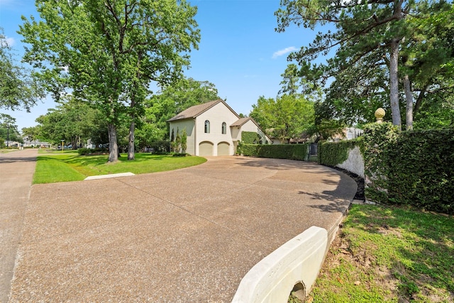 14119 Kiamesha Ct, Houston, TX 77069 - view of front of house featuring an attached garage, driveway, a front lawn, and stucco siding