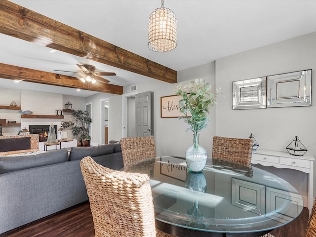 14510 Henry Calfee Dr, Willis, TX 77318 - dining area with dark wood-style floors, beamed ceiling, a glass covered fireplace, and a ceiling fan