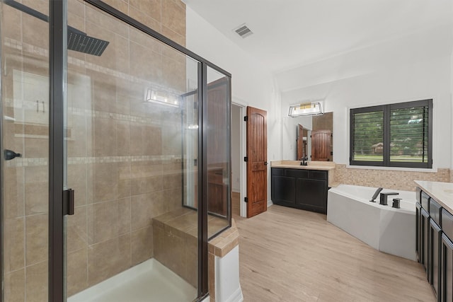 28411 Calaveras Creek Ct, Houston, TX 77336 - full bath with vanity, a garden tub, a shower stall, and wood finished floors