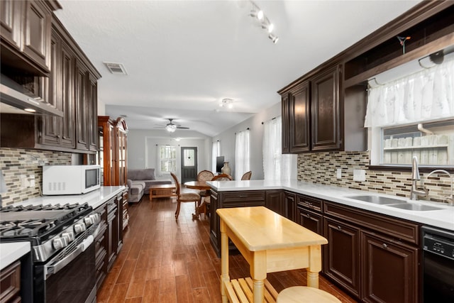 2639 Cypress Island Dr, Houston, TX 77073 - kitchen featuring a sink, stainless steel range with gas stovetop, black dishwasher, white microwave, and light countertops