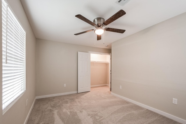 308 Greenbriar Dr, Baytown, TX 77520 - unfurnished bedroom with light colored carpet, baseboards, ceiling fan, a closet, and a walk in closet
