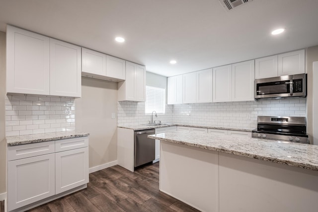 308 Greenbriar Dr, Baytown, TX 77520 - kitchen featuring stainless steel appliances, a sink, dark wood-type flooring, white cabinets, and recessed lighting