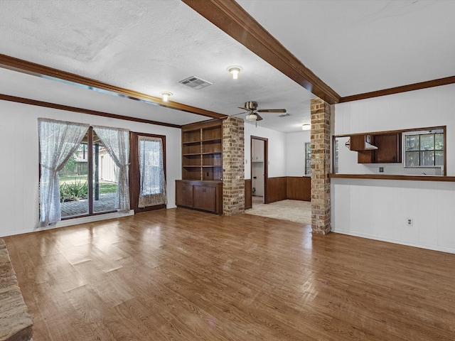 21326 Four Oaks Dr, Houston, TX 77073 - unfurnished living room featuring ornate columns, wood finished floors, ceiling fan, a textured ceiling, and built in shelves