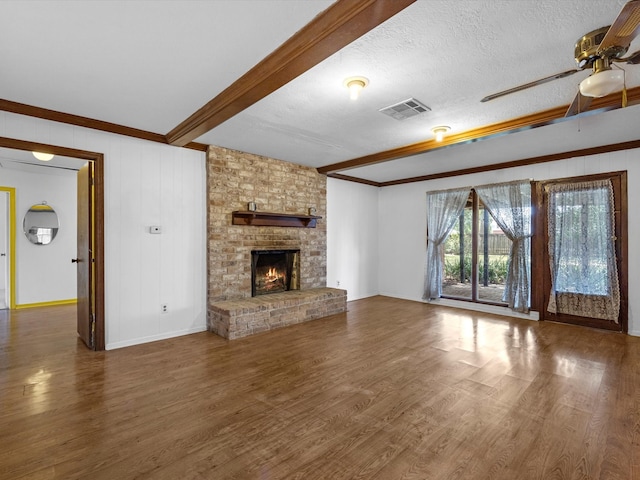 21326 Four Oaks Dr, Houston, TX 77073 - unfurnished living room with a ceiling fan, wood finished floors, ornamental molding, a brick fireplace, and beam ceiling