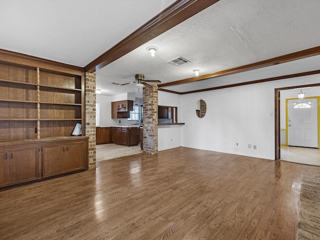 21326 Four Oaks Dr, Houston, TX 77073 - unfurnished living room featuring wood finished floors, ornamental molding, a textured ceiling, ceiling fan, and built in features