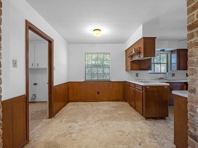 21326 Four Oaks Dr, Houston, TX 77073 - kitchen with a wainscoted wall, plenty of natural light, light countertops, wooden walls, and brown cabinets