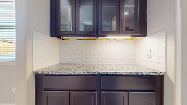 5434 Wildbrush Dr, Richmond, TX 77407 - kitchen featuring decorative backsplash, glass insert cabinets, and light stone counters