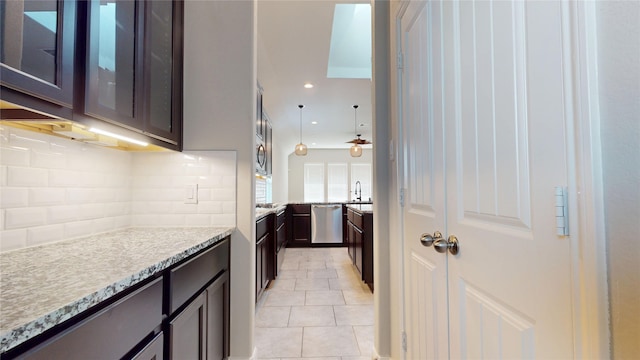 5434 Wildbrush Dr, Richmond, TX 77407 - kitchen featuring stainless steel dishwasher, backsplash, light tile patterned floors, glass insert cabinets, and dark brown cabinets