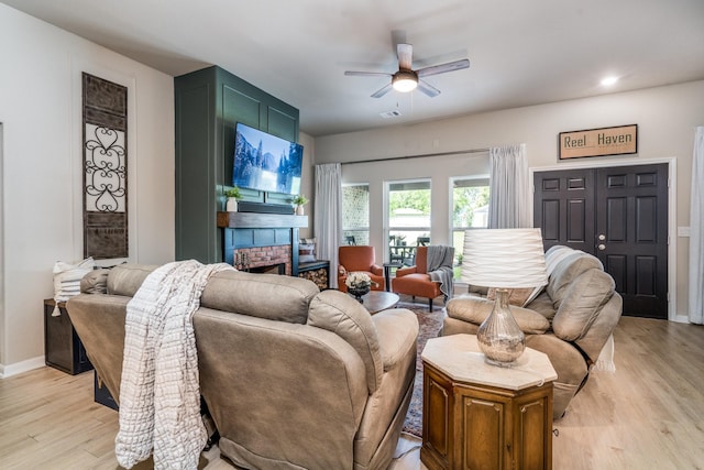 454 Cape Conroe Dr, Montgomery, TX 77356 - living room with ceiling fan, light wood-type flooring, a brick fireplace, and baseboards