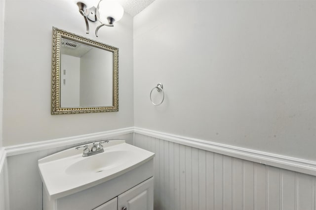 3126 Windchase Blvd Unit 421, Houston, TX 77082 - bathroom featuring a wainscoted wall, vanity, and a textured ceiling