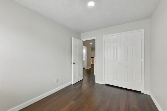 3126 Windchase Blvd Unit 421, Houston, TX 77082 - unfurnished bedroom featuring baseboards, dark wood-style flooring, and a closet