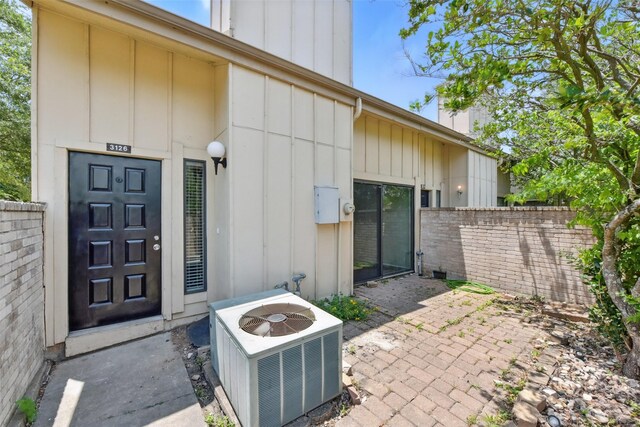 3126 Windchase Blvd Unit 421, Houston, TX 77082 - property entrance featuring central air condition unit, a chimney, board and batten siding, and a patio area