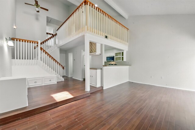3126 Windchase Blvd Unit 421, Houston, TX 77082 - unfurnished living room featuring wood finished floors, ceiling fan, a high ceiling, stairs, and baseboards