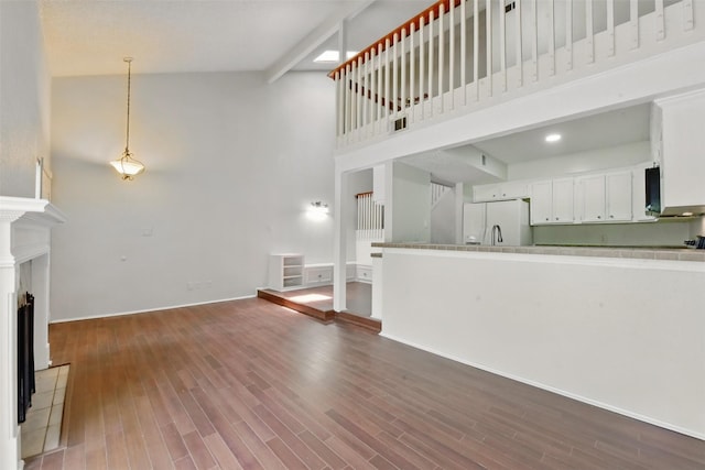3126 Windchase Blvd Unit 421, Houston, TX 77082 - unfurnished living room featuring high vaulted ceiling, wood finished floors, and baseboards