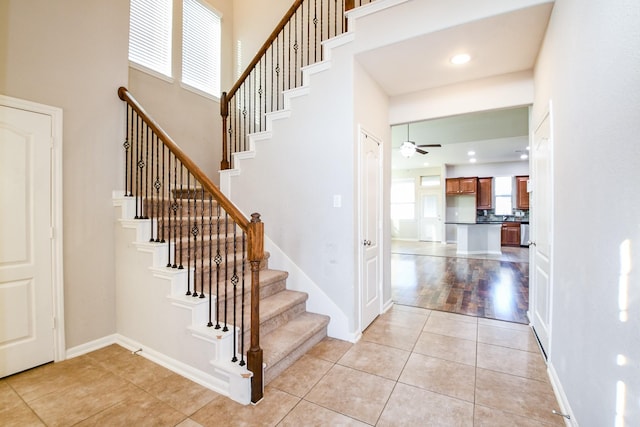 6406 Hunters Way Ln, Baytown, TX 77521 - stairs with a ceiling fan, tile patterned flooring, and a towering ceiling