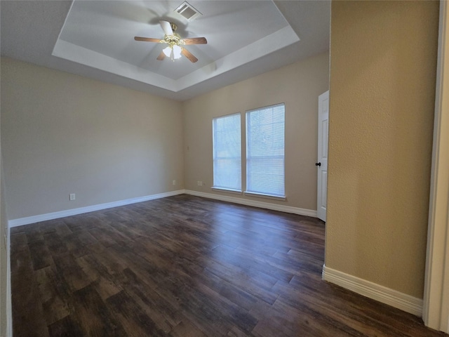 1944 Hillcroft, Prairie View, TX 77445 - spare room featuring a raised ceiling, ceiling fan, dark wood finished floors, and baseboards
