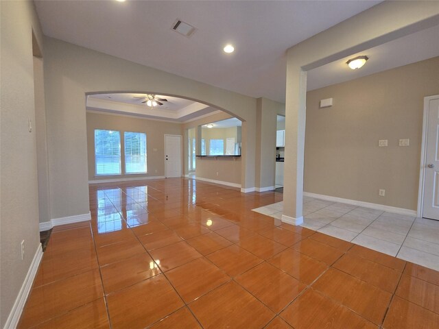 1944 Hillcroft, Prairie View, TX 77445 - spare room with arched walkways, light tile patterned floors, ceiling fan, baseboards, and a raised ceiling