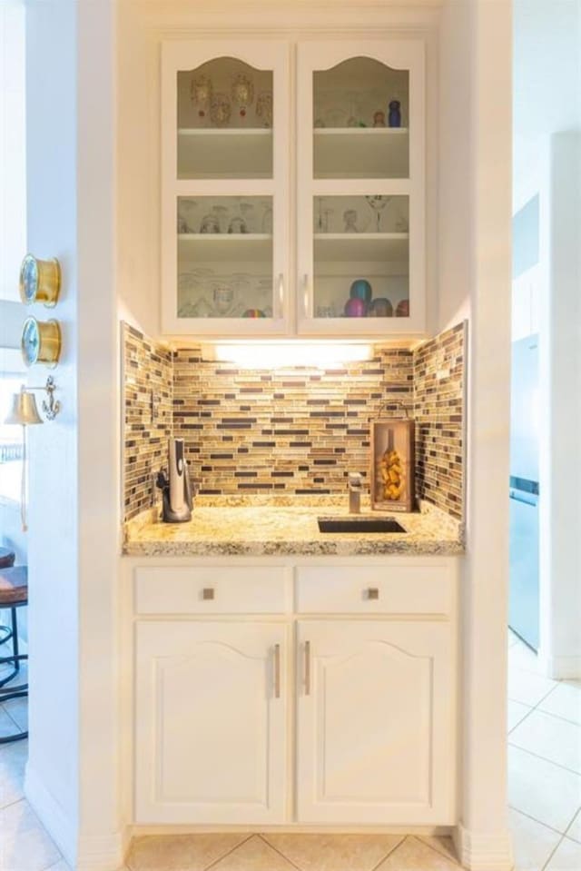 423 Hana Dr, Tiki Island, TX 77554 - bar area with light tile patterned flooring, tasteful backsplash, and a sink