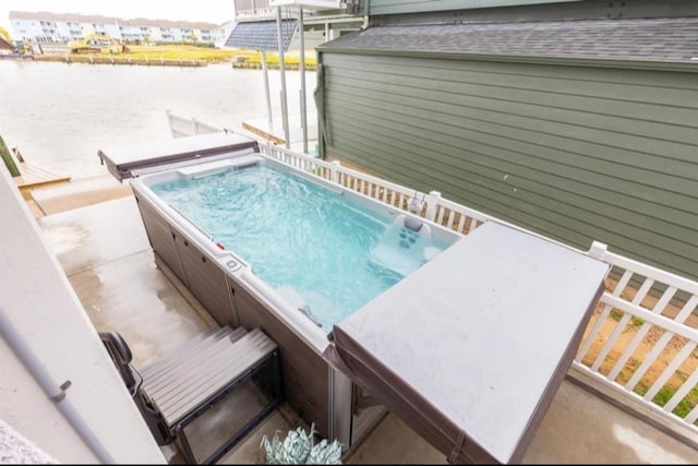 423 Hana Dr, Tiki Island, TX 77554 - view of pool featuring a hot tub and a water view